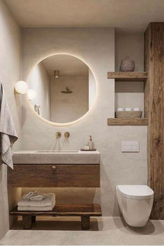 a bathroom with a toilet, sink and mirror in the wall next to a wooden bench