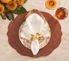 a place setting with napkins and flowers on the table