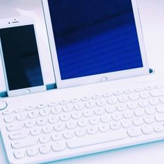 two tablets are sitting on top of a white keyboard and tablet computer, which is connected to the same device