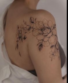 the back of a woman's shoulder with flowers on it