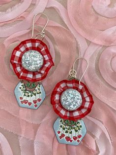 These earrings are chic and fun to wear.  So unique in design and components.  The top portion of these dangles have red and white small print ribbon encasing up-cycled vintage light blue cabs from a vintage set of earrings.  The cabs are so 50's with all the glitter type materials in them.  This is attached to a metal finding that has been painted a dark green.   The lower dangle portion are hand enameled metal with a strawberry motif.  If you follow me at all then you know I adore strawberry jewelry!   The 2 pieces together have great movement when worn and feel so stylish on.   The ear wires and jump rings are silver tone. These will arrive nicely packaged and ready for gift giving if desired.  Measurements: Length is 2-1/2" long, not including the ear wire portion.   Width is 1-1/2" at Blue Pallet, Blue Pallets, Strawberry Jewelry, Assemblage Earrings, Printed Ribbon, Wedding Jewelry Earrings, Small Print, Wedding Earrings, Assemblage