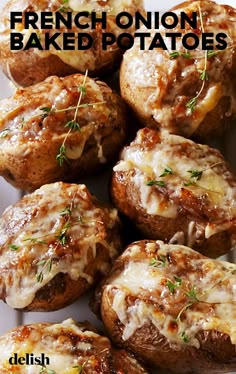 french onion baked potatoes on a white plate with cheese and herbs in the top right corner