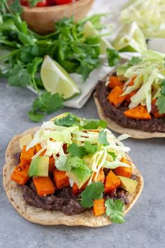 two tortillas topped with meat and veggies on top of a table