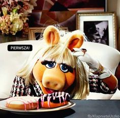 the miss piggy doll is eating a donut with icing on it's face