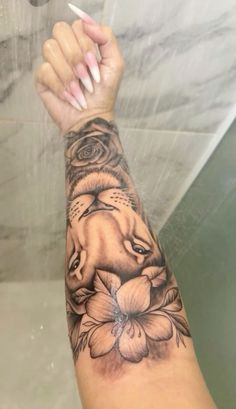 a woman's arm with an elephant and flower tattoo on it