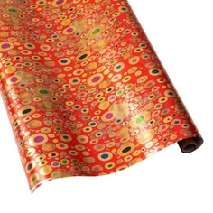 an orange wrapping paper with multicolored circles and dots on it, rolled up