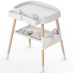 a white baby changing table with two trays on it and some toys in the drawer