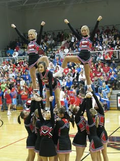 a group of cheerleaders doing tricks on the court