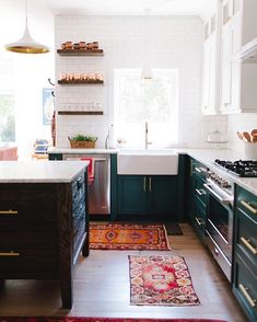 a kitchen with green cabinets and rugs on the floor in front of the sink