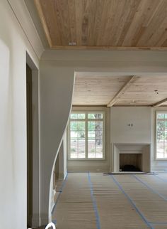 an empty living room with wood ceiling and white paint on the walls is being renovated