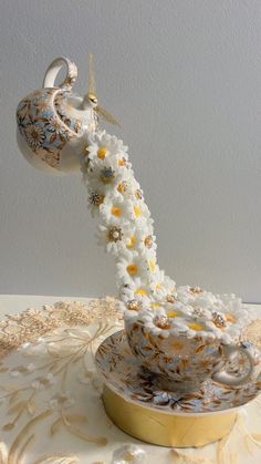 a white and yellow vase with flowers in it