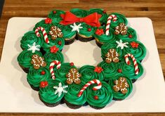 cupcakes decorated with green frosting and candy canes in the shape of a wreath