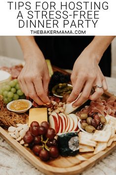 a platter filled with cheese, fruit and crackers on top of a table