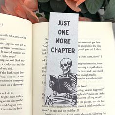 an open book with a skeleton holding a bookmark reading just one more charter on it