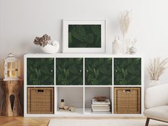 a living room with white furniture and green leaves on the wall behind it is a chair