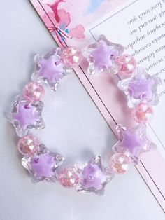 a bracelet with pink and purple stars on it next to a card that says, i love you