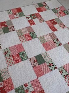 a red and green patchwork quilt on the floor