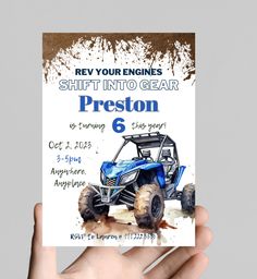 a person holding up a card with an atv on it