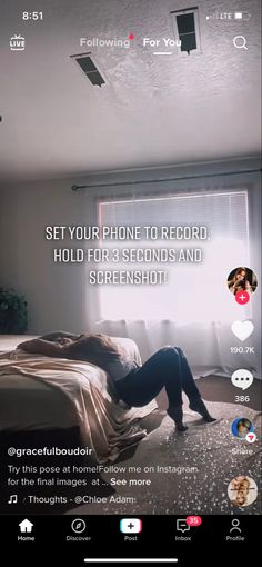 a woman laying on top of a bed next to a window