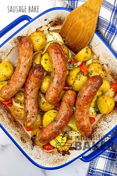 sausage and potatoes in a blue casserole dish with a wooden spoon