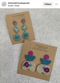 two earrings with flowers on them sitting on top of a piece of brown paper next to each other