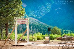 an outdoor ceremony set up in the mountains with chairs and microphones on the ground