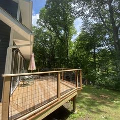 a deck in front of a house surrounded by trees