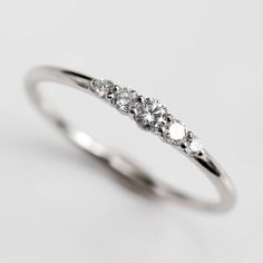 three stone diamond ring in white gold with diamonds on each side and four stones at the top