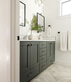 a bathroom with green cabinets and white walls