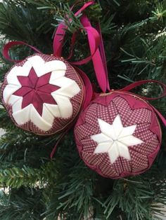 two ornaments are hanging from a christmas tree