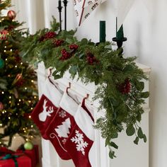 stockings hung on the mantle with christmas decorations