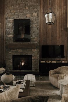 a living room filled with furniture and a fire place in front of a stone fireplace