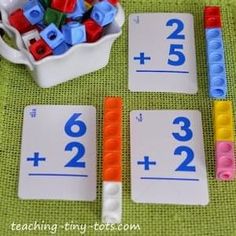 three matching cards with numbers on them next to a bowl of legos and a cup of pens