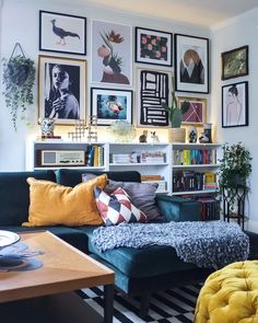 a living room with pictures on the wall and couches in front of bookshelves