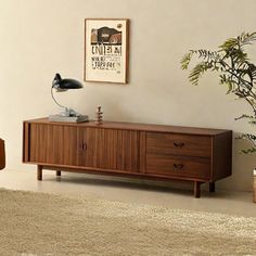 a living room with a couch, table and lamp on it's sideboard