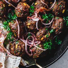 meatballs with onions and herbs in a skillet