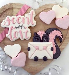 decorated cookies in the shape of hearts on a wooden heart shaped platter that says scent with love