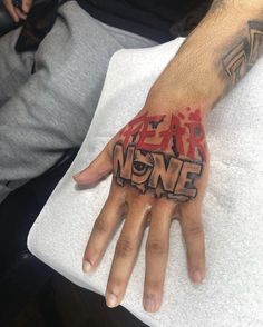 a hand with the words fear none painted on it and someone's left hand