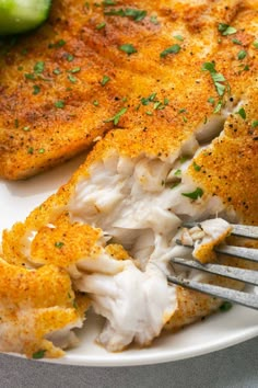 a white plate topped with fish and vegetables