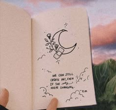 someone holding up a book with an image of a moon and flowers on it that says we can still create art even if it's the same