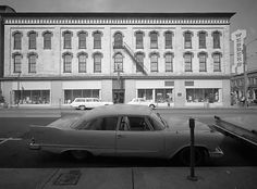 an old car is parked in front of a building