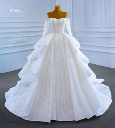 a white wedding dress with long sleeves and beadings on the bouncy