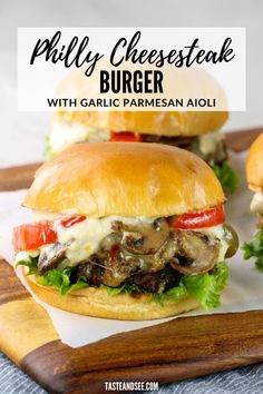 two cheese steak burgers with garlic parmesan aioli on a cutting board