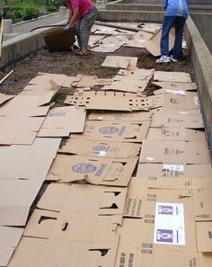 two women are standing next to cardboard boxes on the ground