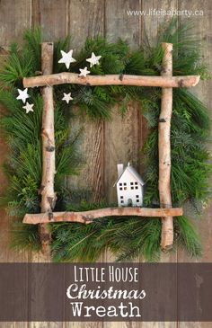 a christmas wreath made out of branches with a house in the middle and stars on top