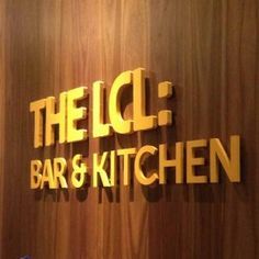 the ice bar and kitchen is located in front of a wood paneled wall with gold lettering