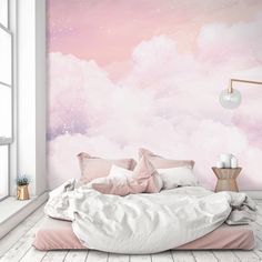 a bedroom with pink and blue clouds painted on the wall, bed in foreground