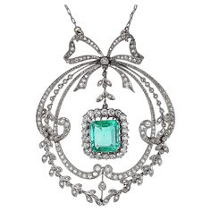 Platinum, white gold, Antique Edwardian diamond, and emerald pendant necklace. The edwardian era was called Belle époque (beautiful era) in France. The delicate center emerald weighs 3.29 carats and is an old emerald cut. A combination of Old European Cut and Single Cut diamonds surrounds the emerald. The attention to detail and intricate craftsmanship are showcased throughout the pendant in 18-karat white gold and platinum. The lace-like open metal design is what makes the Victorian Era so beau Victorian Diamond Pendant Necklace For Formal Occasions, Victorian Style Pendant Diamond Necklace For Formal Occasions, Elegant Formal Emerald Necklace With Intricate Design, Emerald Pendant Necklace, The Edwardian Era, Emerald Necklace Pendant, Edwardian Jewelry, Emerald Pendant, Edwardian Era