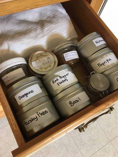 several jars with labels on them sitting in a drawer