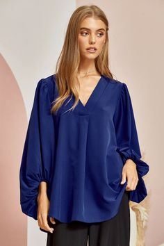 Blue is the color of the sky and sea, and in this blouse it’s the color of confidence. With a flowing silhouette and 3⁄4 sleeves that billow with carefree spirit, the Be Yourself top invites you to embrace your true self. Made for turning heads with every flutter of its fluid bodice, this ravishing royal blue top is a sartorial reminder that style knows no limits. Pair it with white denim for a nautical vibe or a boldly printed bottoms to really make a statement. However you style it, one thing’ Blue Blouse With Balloon Sleeves For Work, Elegant Blue Blouse With Pleated Sleeves, Solid Color Flowy V-neck Blouse, Flowy Solid Color V-neck Blouse, Flowy Solid V-neck Blouse, Elegant Blue Blouse With Gathered Sleeves, Flowy V-neck Blouse, Flowy Long Sleeve Blouse With Gathered Sleeves, Chic Oversized Blue Blouse